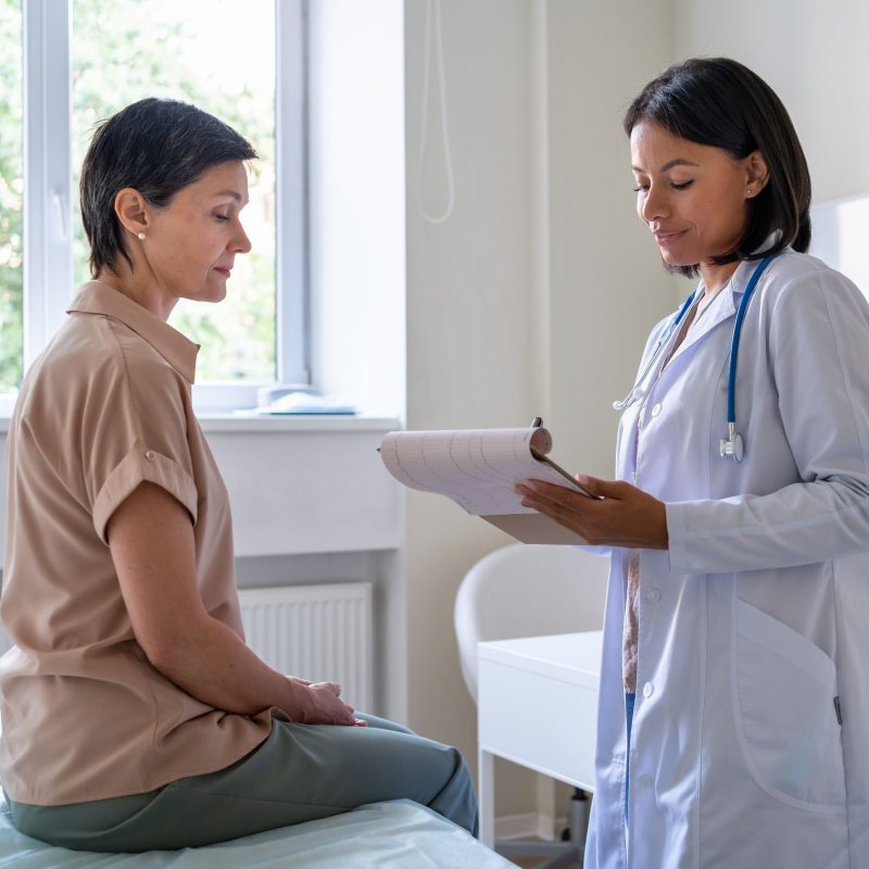 doctor-giving-prescriptions-on-clipboard-to-middle-2024-10-14-22-41-46-utc